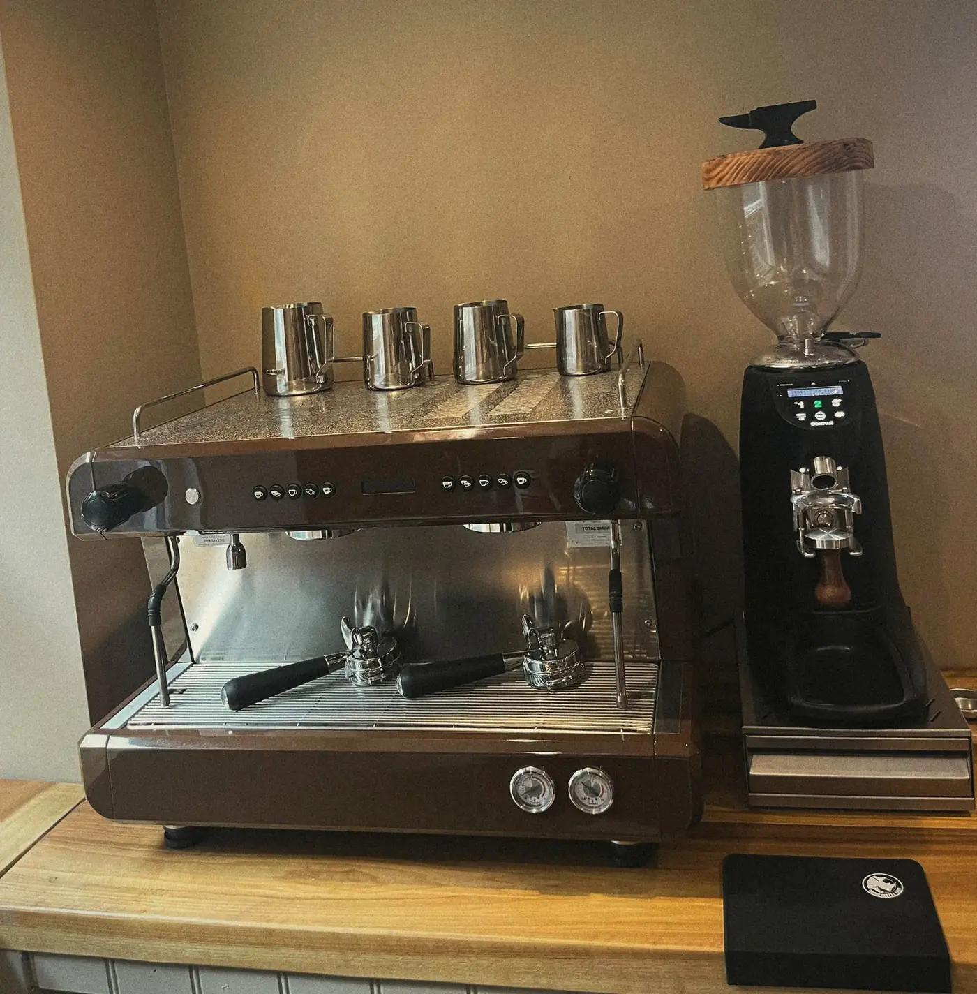 The espresso machine and grinder behind the counter