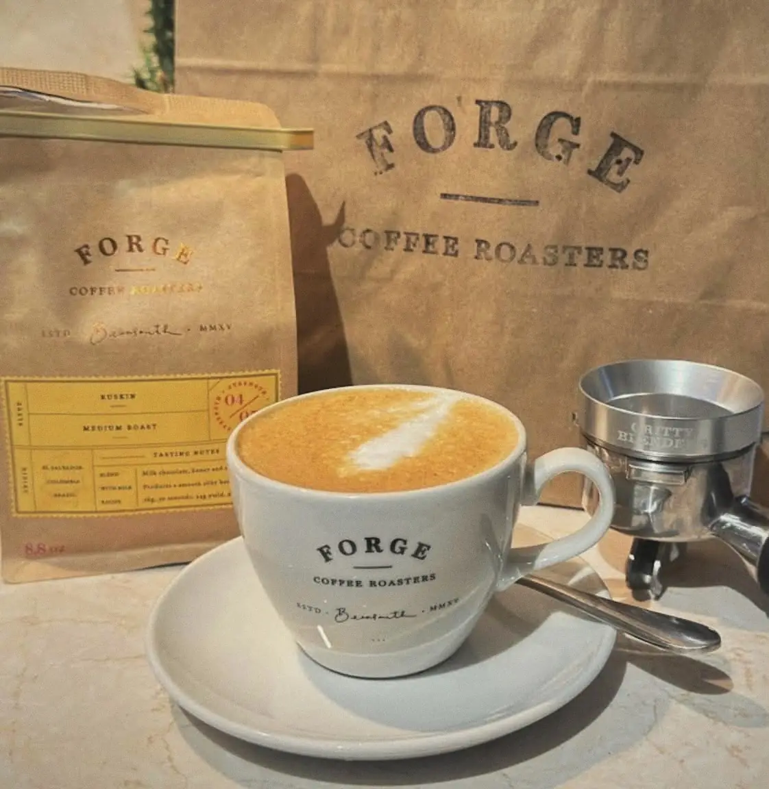 A flat white with latte art in a Forge Coffee Roasters cup